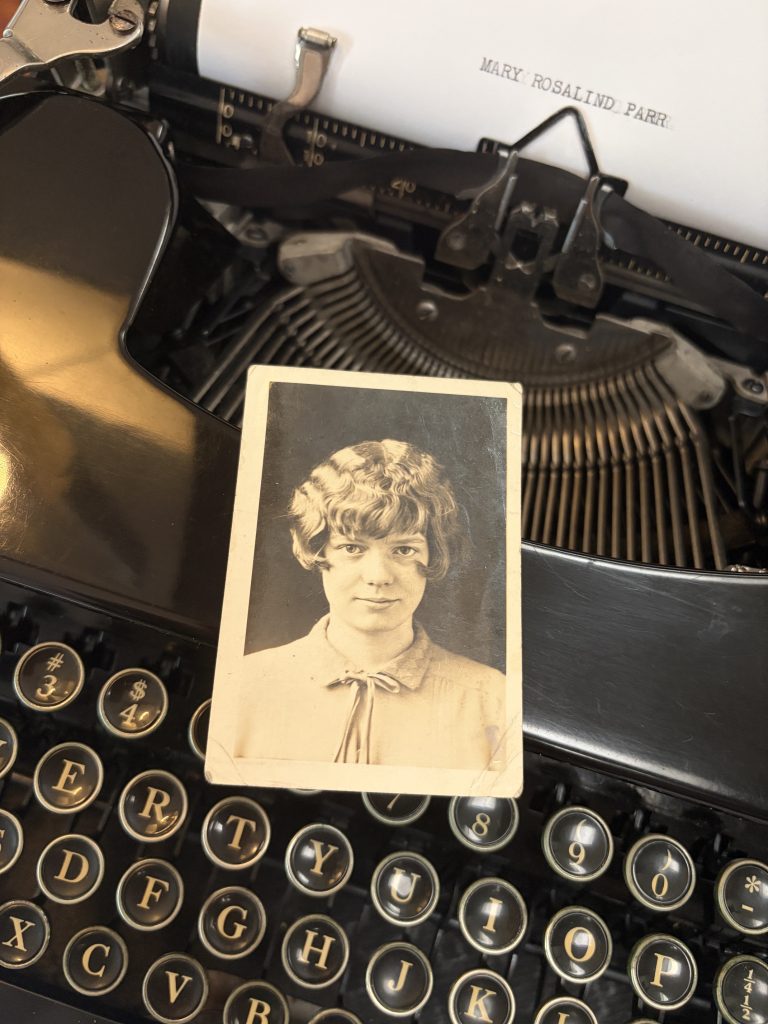 Mary Rosalind Parr school photograph posed on an old typewriter