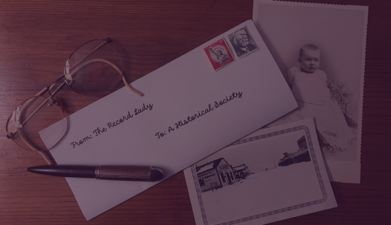 Letter addressed to a historical society on a desk with photographs.